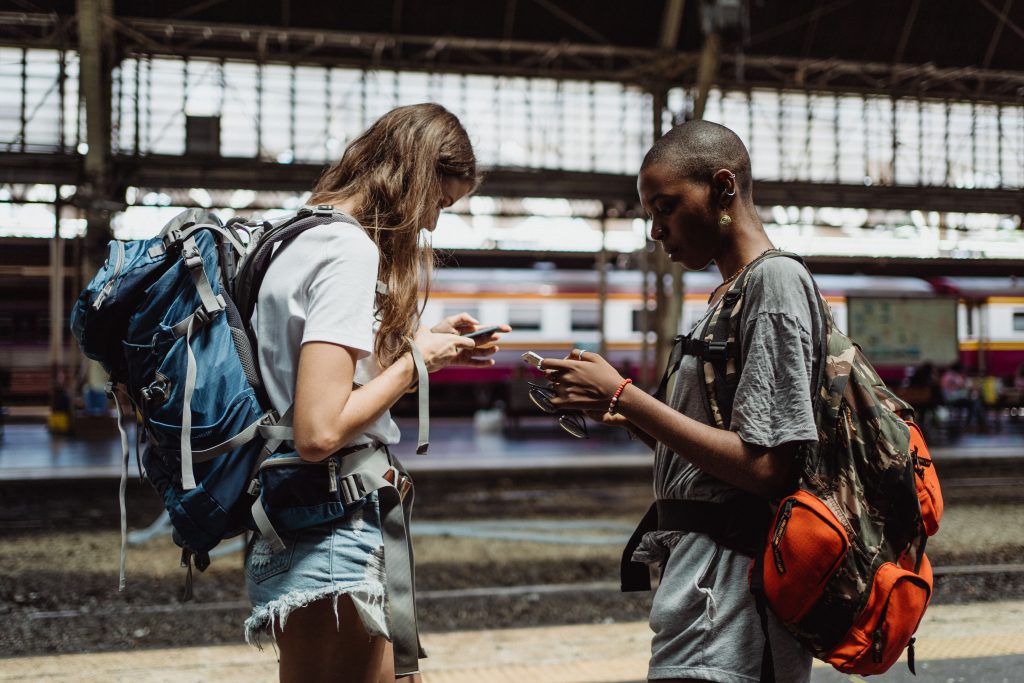 Deux voyageuses consultent des idées de visites sur leur smartphone
